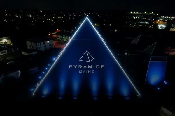 Beleuchtete Fassade der Pyramide Mainz mit großflächigem Branding